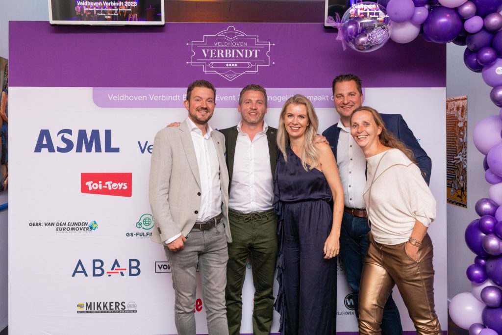 Groep mensen poseert voor Veldhoven Verbindt event banner.