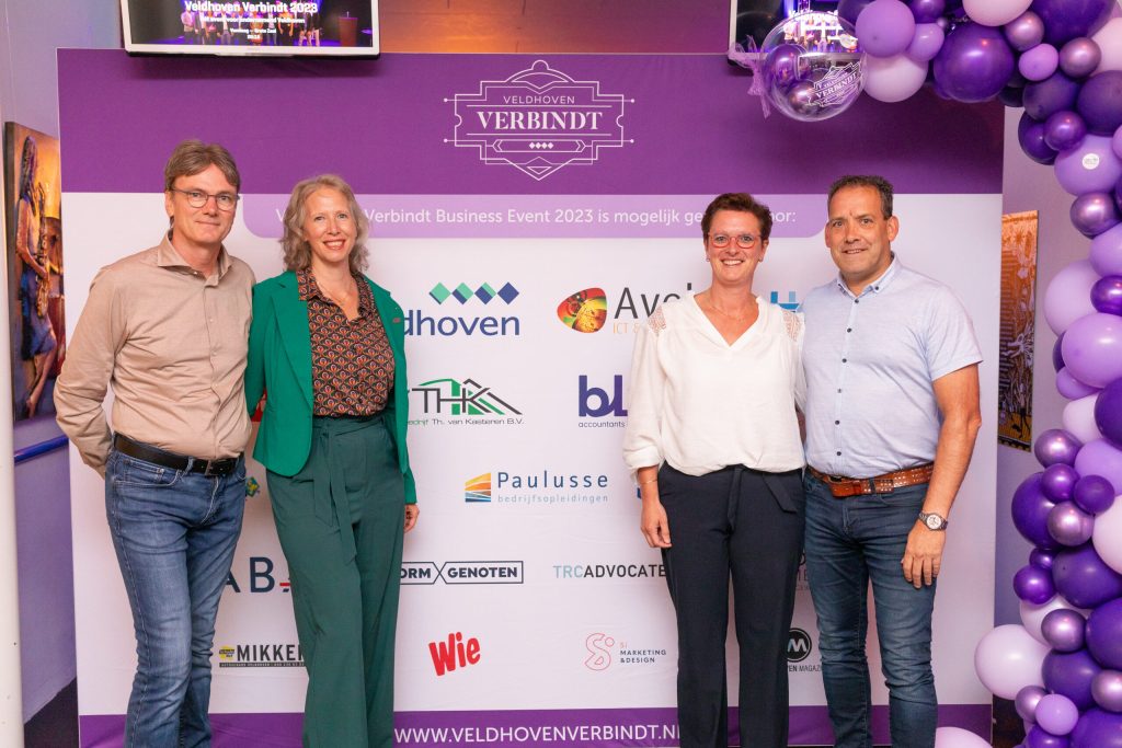 Vier mensen bij Veldhoven Verbindt evenement banner.