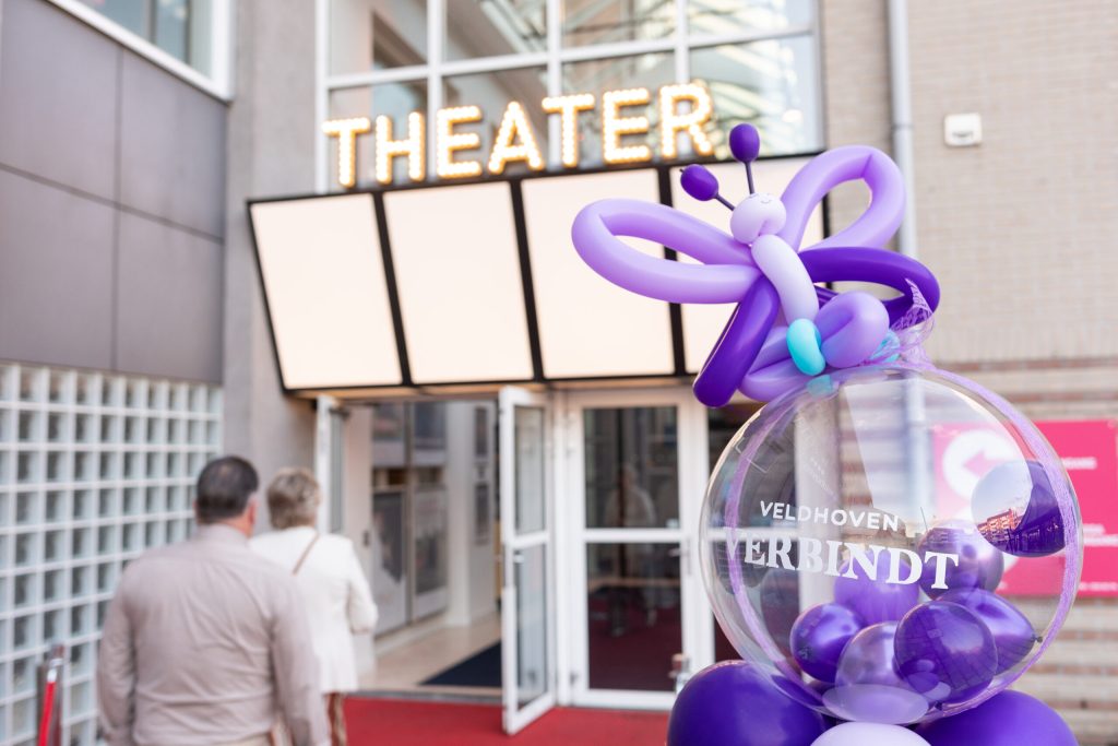 Vooraanzicht theater met paarse ballonvlinder