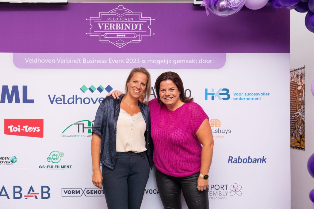 Twee vrouwen bij Veldhoven Verbindt banner evenement.
