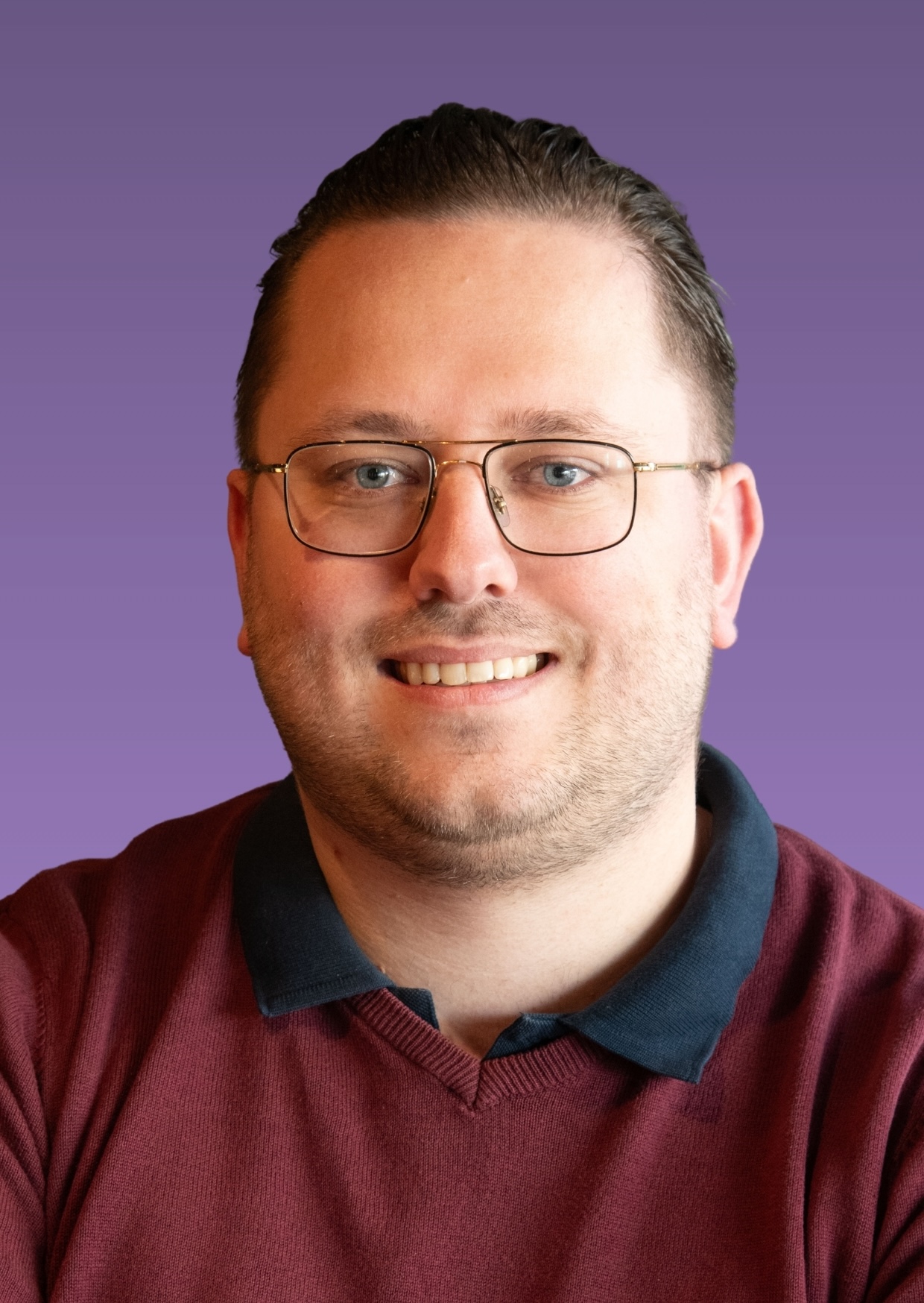 Man met bril en bordeaux trui